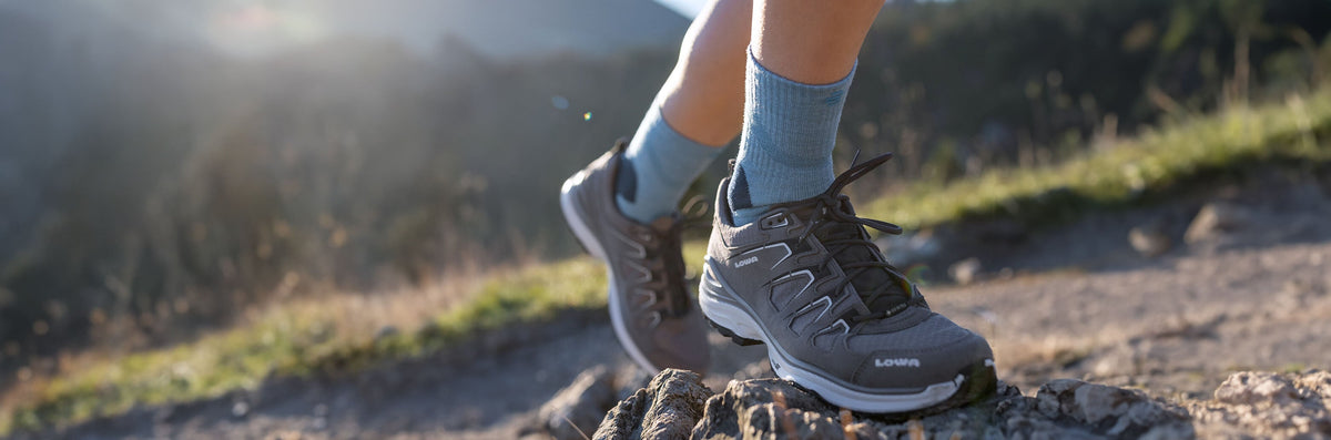 Walker in hiking boots on a rocky path